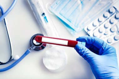 Bir doktorun elinde bir şişe kan örneği var. Kopya alanı olan bir arkaplan. Yatay.