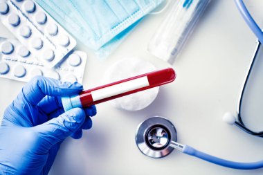 Bir doktorun elinde bir şişe kan örneği var. Kopya alanı olan bir arkaplan. Yatay.