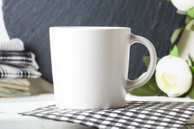 White mug on a background of flowers . Mock up. Template Space for creative artwork. Lettering text product promotion branding.