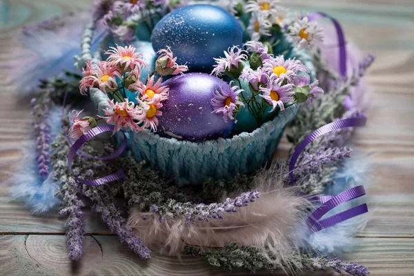 Happy Easter. Congratulatory easter background. Easter eggs and flowers. Background with copy space. Selective focus. Top view.