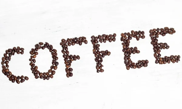 Die Inschrift Kaffee aus Kaffeebohnen ausgelegt. isoliert auf whi — Stockfoto