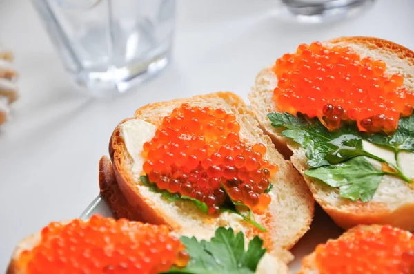 Foto de baguette con caviar rojo sobre mesa blanca — Foto de Stock