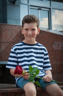 bir gül tutan ve gülen çocuk. aşk kavramı.