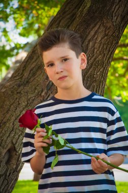bir gül tutan ve gülen çocuk. aşk kavramı.