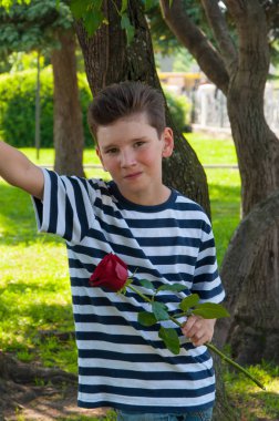 bir gül tutan ve gülen çocuk. aşk kavramı.