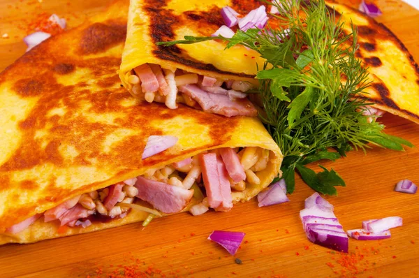 Quesadilla z szynką i serem cebuli i ziół na podłoże drewniane — Zdjęcie stockowe