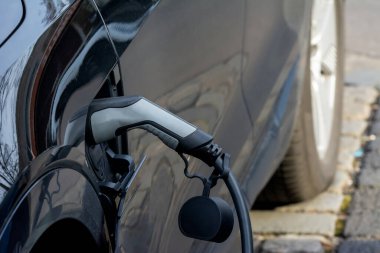 Fişi ve kablosu olan elektrikli bir arabanın şarjı.