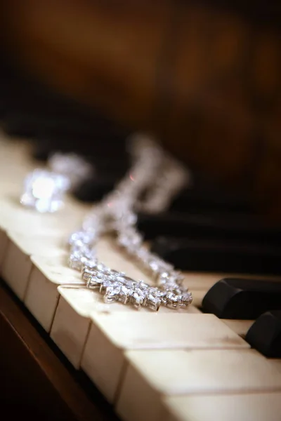 Colar que põe em teclas de piano — Fotografia de Stock