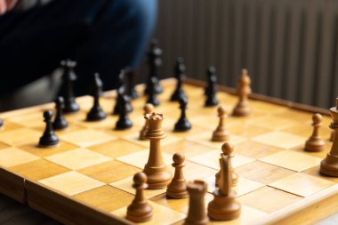 Satranç oynanan bir oyun, tahtada tanınmayan bir adamın bir parçasıyla görmek.