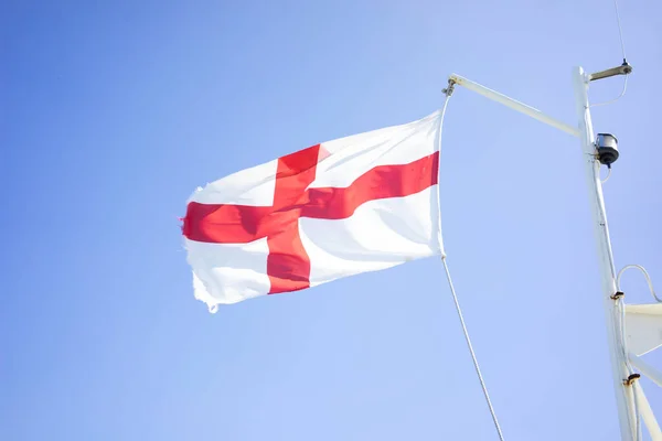 夏には柔らかい雲と青い空に対して船の旗竿に英語の旗 — ストック写真