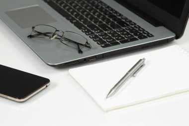dizüstü bilgisayar, telefon, not defteri, kalem, gözlük