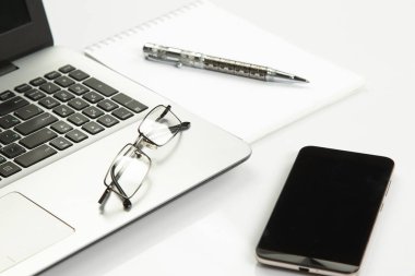 dizüstü bilgisayar, telefon, not defteri, kalem, gözlük