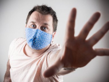 Ev yapımı maskeli genç adam yardım için uzanıyor.