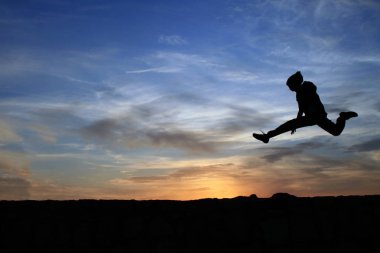 Çocuk kayaların üzerinden atlama