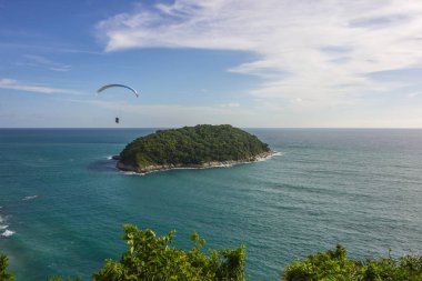 Paragliding over the small island in the sea