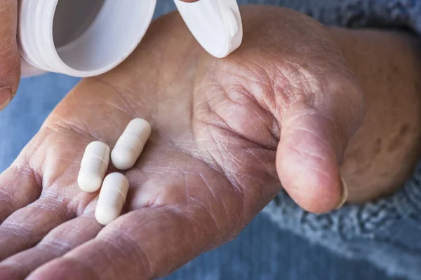 Drug pills on old woman's hand Royalty Free Stock Photos