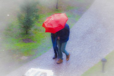 Genç çift yağmurlu havada yürüyüş