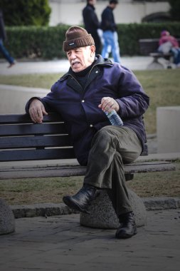 Eski de Izmir (Türkiye bir bankta oturan adam)