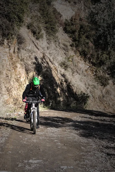 Homem está montando sua bicicleta em um caminho de montanha — Fotografia de Stock