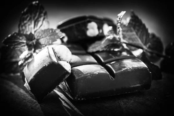Chocolate con nueces y menta fresca en una bandeja de madera - blanco y negro —  Fotos de Stock