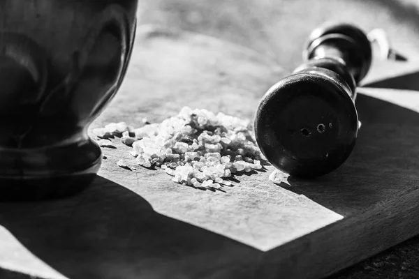 Thick grains of salt and the pestle to grind it - black and white