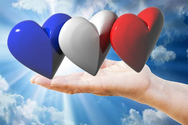 Fransızca / İngilizce bayrak renkleri ile üç hearts tutan kadının el — Stok fotoğraf