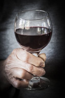 Bir bardak kırmızı şarap tutan kadının el