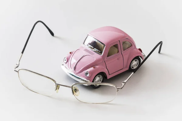 Voiture jouet rose est sur un bureau blanc près des lunettes — Photo