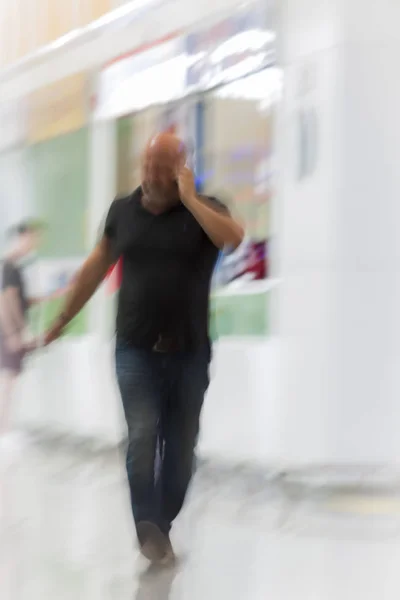 Ο άνθρωπος περπατάει ενώ μιλάει στο κινητό τηλέφωνο — Φωτογραφία Αρχείου