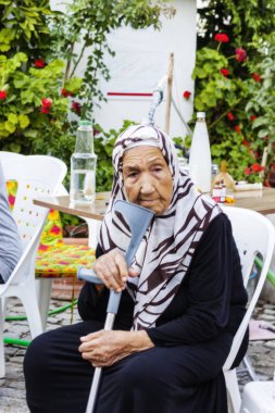Sokağı'nda oturan eski engelli Türk Bayan portresi