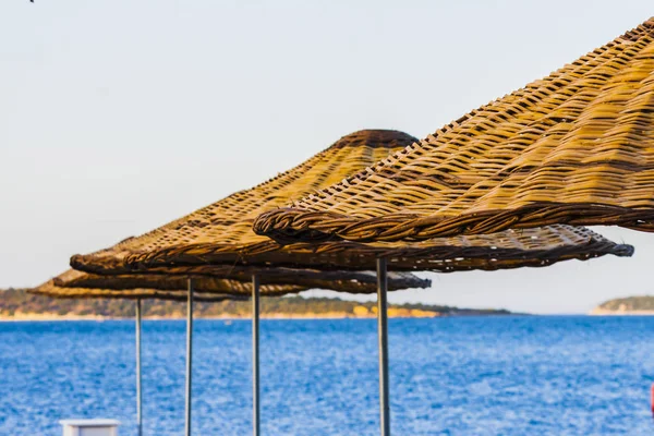 Sonnenschirme aus Holz am Meer — Stockfoto