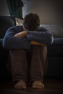 Hüzün içinde kaldırım oturan genç adam