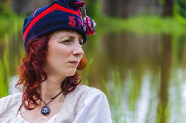 Napolyon döneminin merak yüz ifadesi ile çimlerde oturan kadın