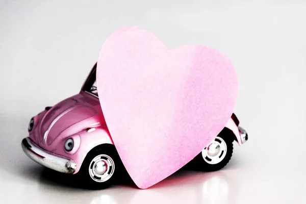 Розовое сердце на розовой игрушечной машине — стоковое фото