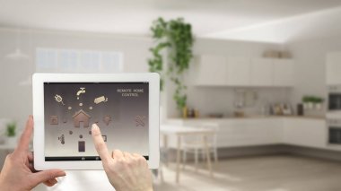 Akıllı uzaktan ev kontrol sistemi dijital tablet. Aygıt app simgeleri ile. Bulanık iç mimari tasarım arka planda beyaz mutfak