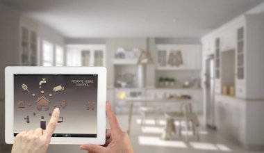 Akıllı uzaktan ev kontrol sistemi dijital tablet. Aygıt app simgeleri ile. Bulanık iç mimari tasarım arka planda İskandinav mutfağı