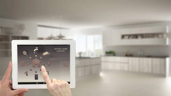 Akıllı uzaktan ev kontrol sistemi dijital tablet. Aygıt app simgeleri ile. Bulanık iç mimari tasarım arka planda minimalist mutfak — Stok fotoğraf