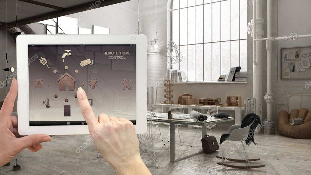 Smart remote home control system on a digital tablet. Device with app icons. Interior of industrial office in the background, architecture design.