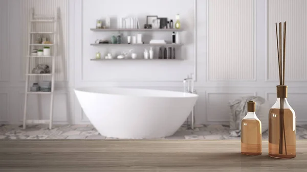 Mesa o estante de madera con botellas de palos aromáticos sobre un cuarto de baño clásico borroso con bañera, diseño interior de arquitectura blanca — Foto de Stock