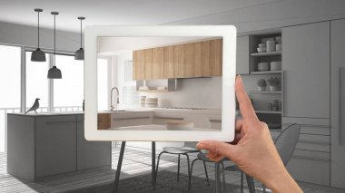 Gerçek gösterilen tablet tutan el minimalist beyaz ve ahşap Mutfak bitmiş. Modern mutfak Cad kroki veya arka planda, mimari iç tasarım sunum çizim