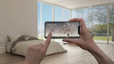 Uzaktan ev kontrol sistemi dijital akıllı telefon tablet. Aygıt app simgeleri ile. İç mimari tasarım arka planda minimalist beyaz yatak odası.