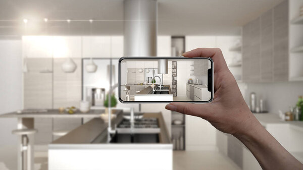Hand holding smart phone, AR application, simulate furniture and interior design products in real home, architect designer concept, blur background, modern kitchen