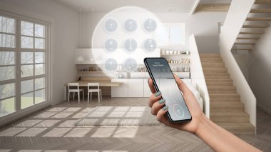 Telefon uygulamasında akıllı ev teknolojisi arayüzü, artırılmış gerçeklik, şeylerin interneti, bağlı nesnelerle modern mutfağın iç tasarımı, kadın el kumandası cihazı
