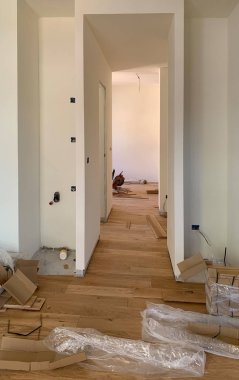 Parke döşeme, onarım, inşaat ve ev konsepti olan bir odanın yenilenmesi. Meşe kalasları ve beyaz duvarlar