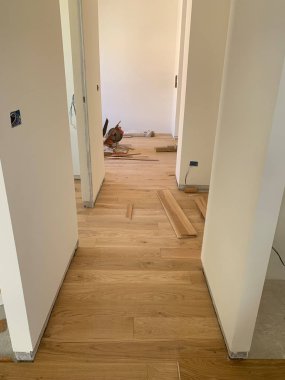 Parke döşeme, onarım, inşaat ve ev konsepti olan bir odanın yenilenmesi. Meşe kalasları ve beyaz duvarlar