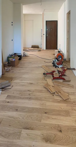 Renovation of a room with laying out parquet , repair, building and home concept. Oak planks and white walls