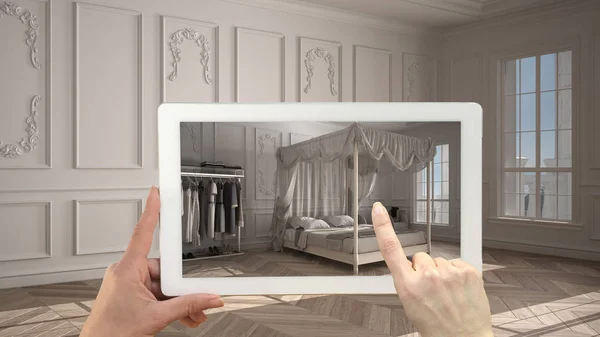 Augmented reality concept. Hand holding tablet with AR application used to simulate furniture and design products in empty interior with parquet floor, classic bedroom with canopy bed