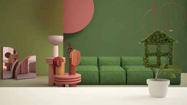 Vit bordsskiva eller hylla med grön växt i kruka formad som hus, grön färgat modernt vardagsrum bakgrund, inredning, fastigheter, eko arkitektur koncept idé — Stockfoto