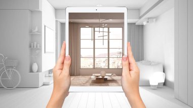 Modern oturma odasını, büyük pencereyi, tamamen boş proje geçmişini, artırılmış gerçeklik kavramını, mobilya ve iç tasarım ürünlerini taklit etmek için uygulamayı gösteren tableti tutan eller