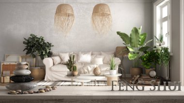 Çakıl taşı dengeli klasik ahşap masa rafı ve eski tarz oturma odasının üzerinde eski tarz Feng Shui yazan üç boyutlu harfler bej rengi renkler, kanepe, yastıklar, bitkiler, zen konsept iç tasarım.